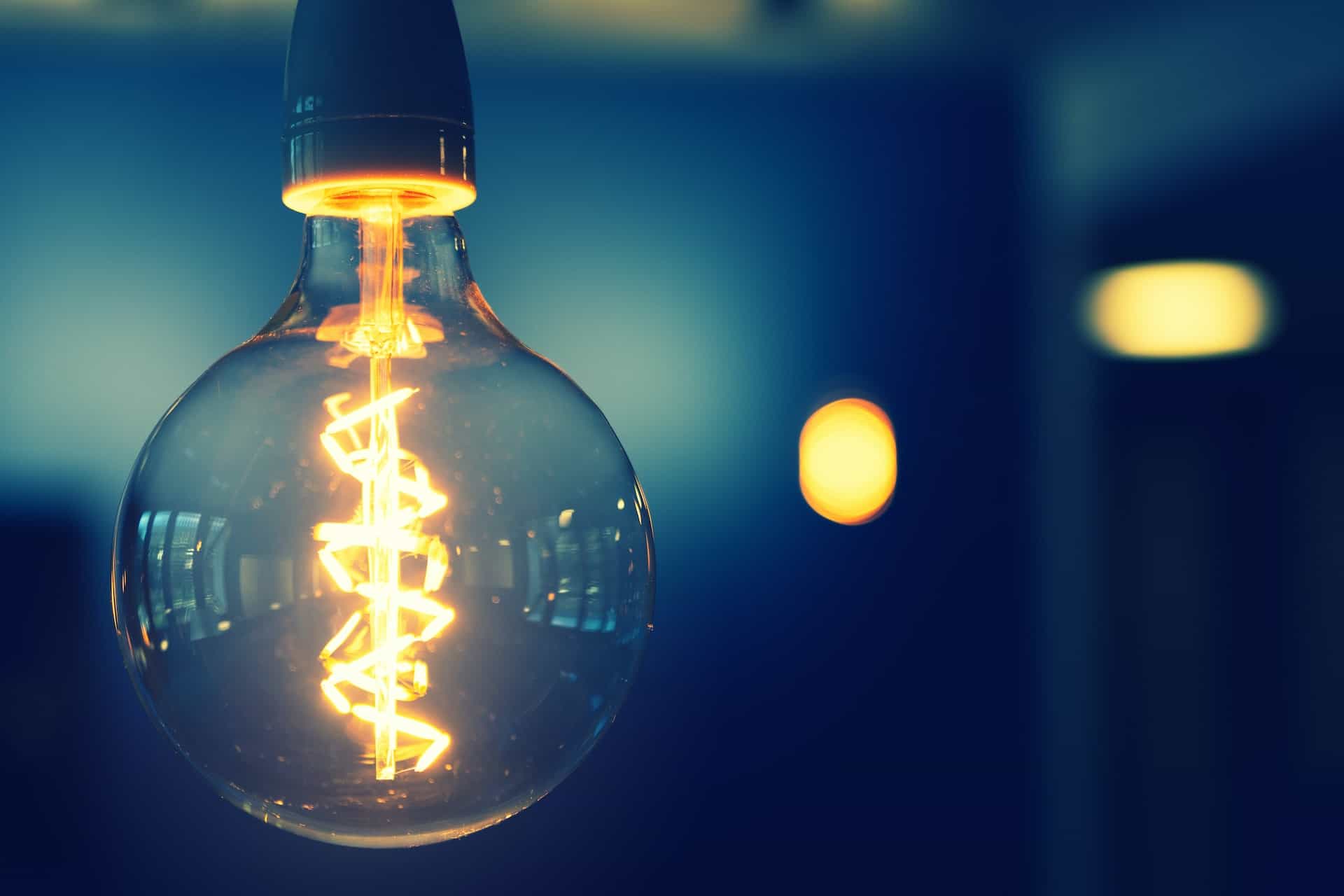 A light bulb is lit up in a dark room.
